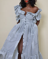 Model wearing The Kemist Barletta Backless Dress in White on a plain cream backdrop. 