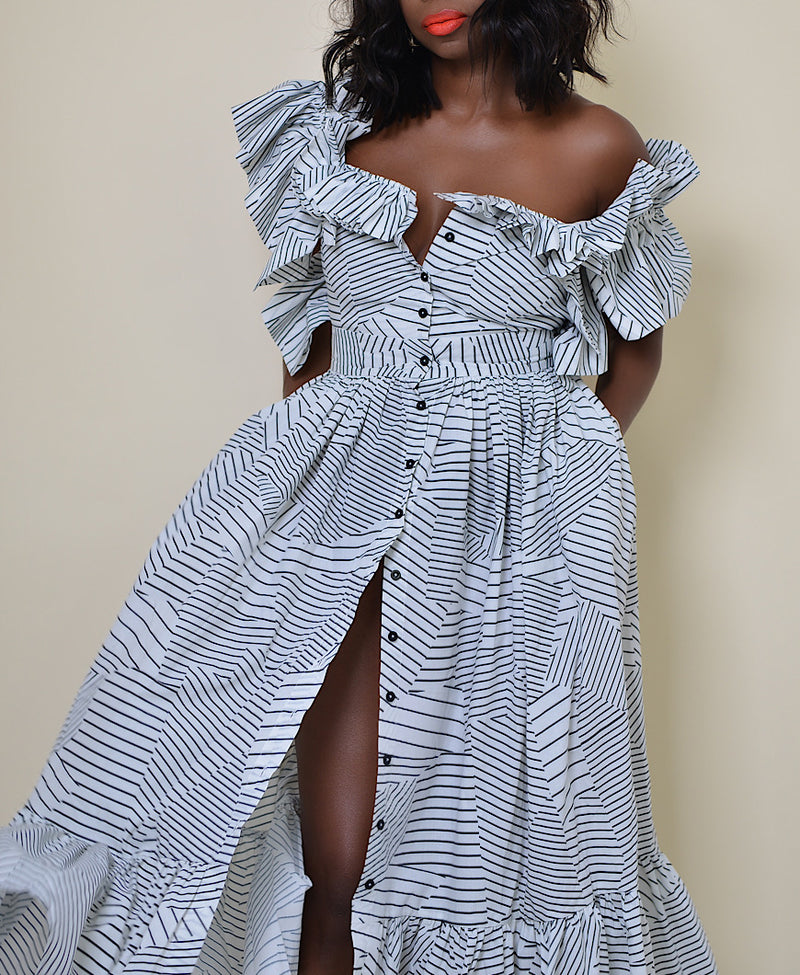 Model wearing The Kemist Barletta Backless Dress in White on a plain cream backdrop. 