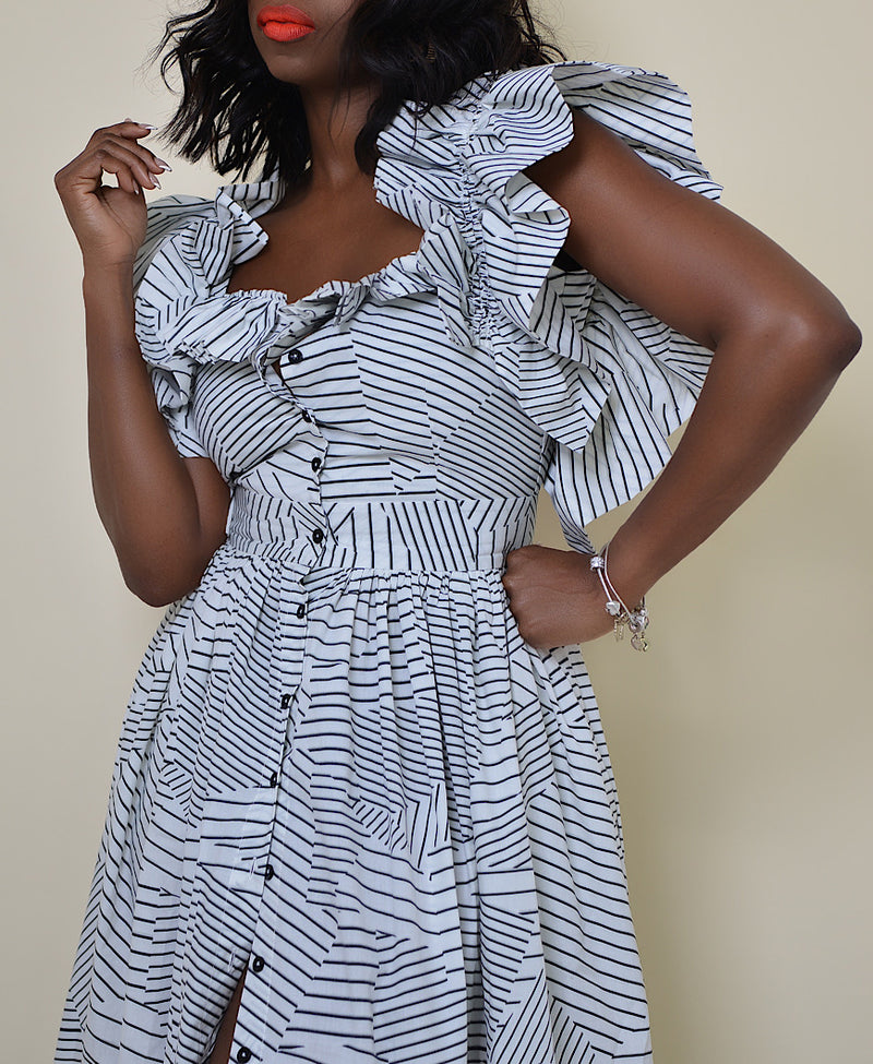 Model wearing The Kemist Barletta Backless Dress in White on a plain cream backdrop. 