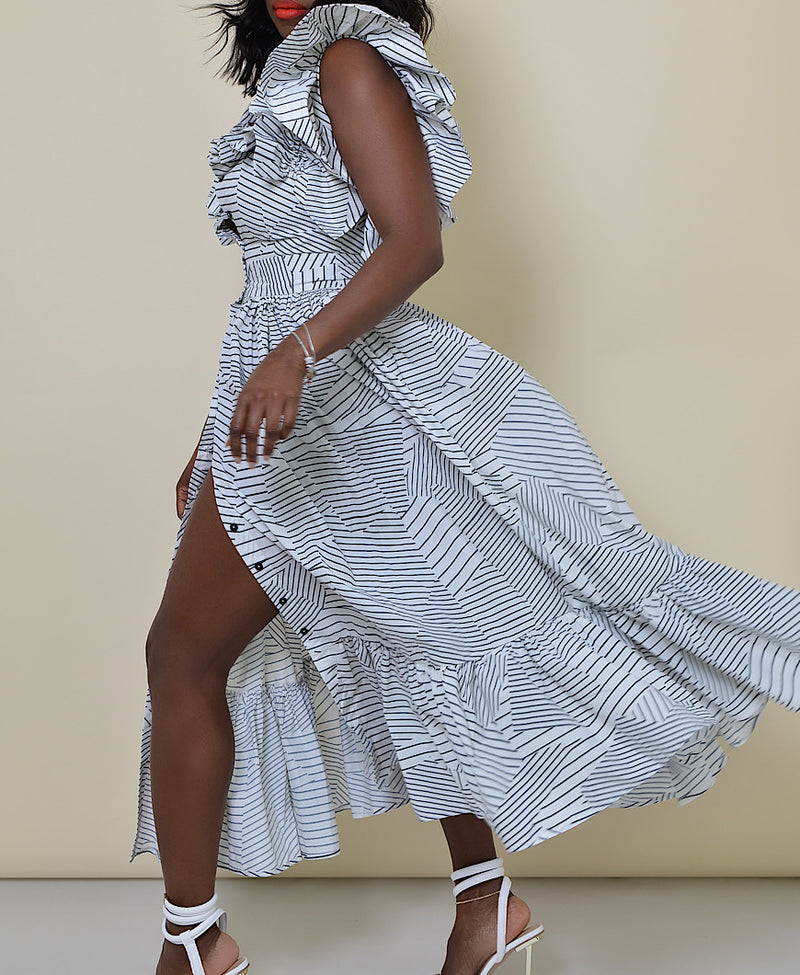 Model wearing The Kemist Barletta Backless Dress in White on a plain cream backdrop. 