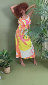Model wearing The Kemist Sicily Slip Dress in Kayseri Print on an cream backdrop with flower props 